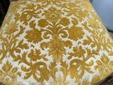 an old chair with a yellow and white damask pattern on it