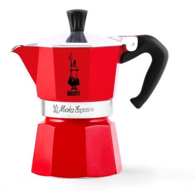 une cafetière rouge posée sur une table blanche