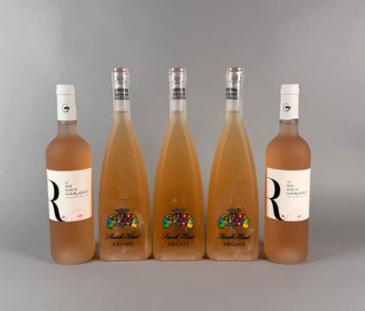 quatre bouteilles de vin sont alignées sur une surface grise