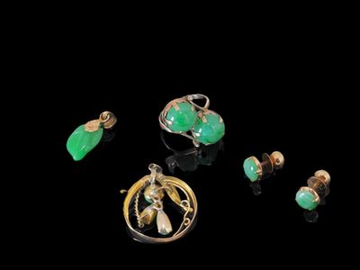 un ensemble de bijoux verts et dorés sur un fond noir