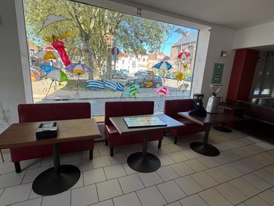 des tables et des chaises devant une grande baie vitrée dans un restaurant
