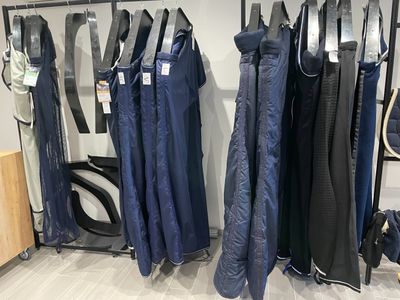 de nombreux parapluies suspendus à un porte-parapluies dans un magasin