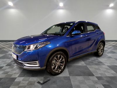 un 4x4 bleu garé sur un sol en damier dans un garage