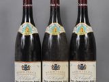 trois bouteilles de vin sont alignées sur une table