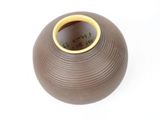 a brown vase with a yellow rim sitting on a white surface