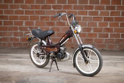 a small motorcycle parked in front of a brick wall