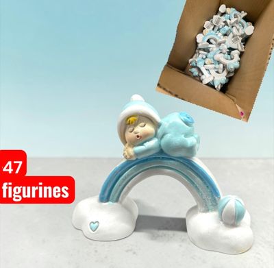 a small figurine of a baby sleeping on top of a rainbow