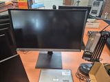 a computer monitor sitting on top of a desk next to a laptop