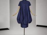 mannequin portant une robe bleue à pois blancs