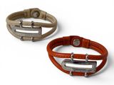 two leather bracelets with metal clasps on a white background