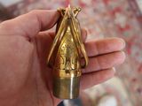 a person holding a small gold object in their hand
