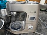 a silver mixer sitting on a kitchen counter next to a pot