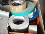 many rolls of tape in a box on the floor
