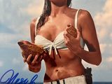 une photo d'une femme en bikini tenant un sandwich