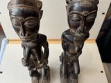 deux statues en bois posées sur une table