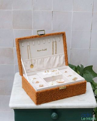 a jewelry box sitting on top of a table next to a potted plant