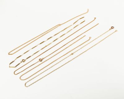 a close up of a bunch of gold chains on a white surface