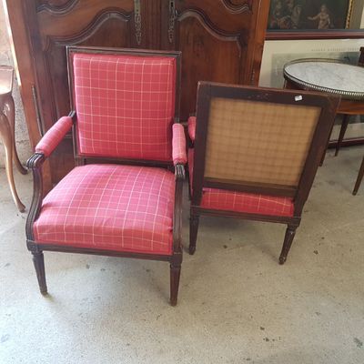 une paire de fauteuils rembourrés roses et marron placés devant un meuble en bois