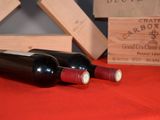 two bottles of wine sitting on a red table cloth