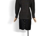 une photo d'un mannequin vêtu d'une chemise et d'une jupe à carreaux noirs et marron