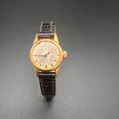 une image d'une montre-bracelet en or avec un bracelet en cuir noir