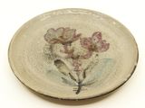 a small plate with flowers on it on a white surface