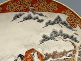 a plate with a picture of a woman and a dog in the snow