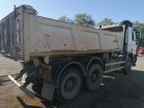 a white dump truck that is parked in the dirt