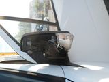 a close up of a car ' s side view mirror with a car in the background