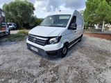 La camionnette blanche est garée sur le gravier, près des arbres.