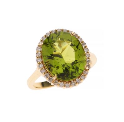 gros plan d'une bague avec une pierre verte entourée de diamants