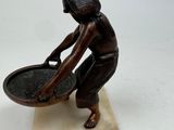 statue of a woman holding a bowl and a pan on a marble base