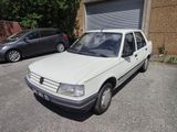 une voiture blanche garée dans un parking à côté d'un bâtiment