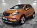 Le SUV Buick orange est garé sur un sol à damier.
