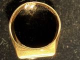 a gold ring sitting on a black surface