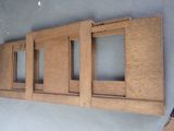 four wooden frames on the wall of a room