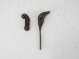 pair of antique wooden canes on a white surface with a white background