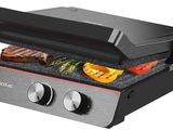 a close up of a grill with meat and vegetables on it