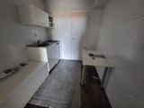 a small kitchen with a white refrigerator and white cabinets