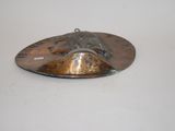 a metal object on a white surface with a white background
