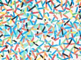 multicolored confetti sprinkles are scattered on a white surface