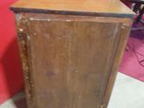 a small wooden cabinet with a door on top of it