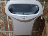 a urinal in the corner of a tiled bathroom