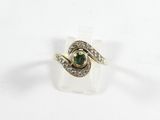 gros plan d'une bague avec une pierre verte entourée de diamants