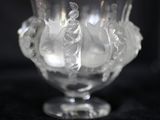 un vase en verre transparent contenant des fleurs, posé sur une surface noire