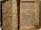 un vieux livre, dont une page est ouverte, posé sur une table
