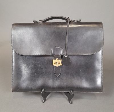 leather briefcase with a lock on the front of it on a gray background
