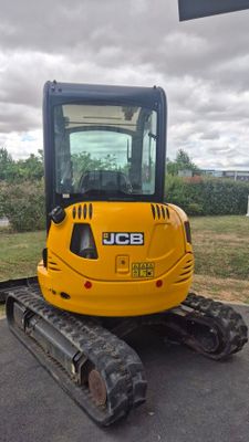 un petit engin de chantier jaune garé sur un parking