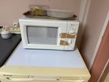 a microwave sitting on top of a yellow microwave oven