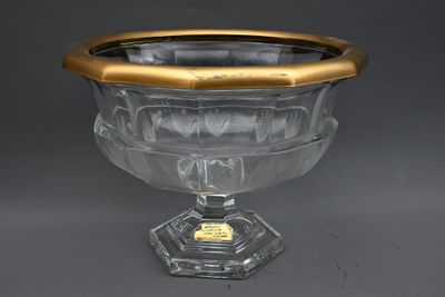 un bol en verre ancien, orné d'une bordure dorée, trône sur un socle